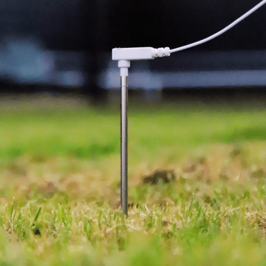 Aardingspin in het gras gestoken