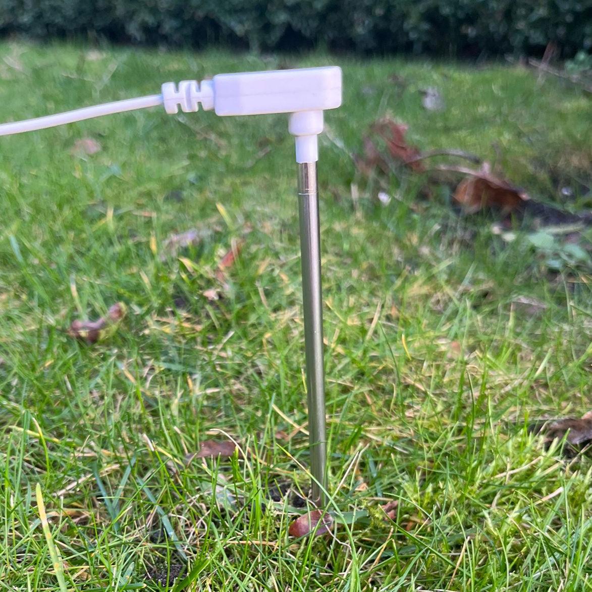 De aardingspin in het gras gestoken voor goede aarding.