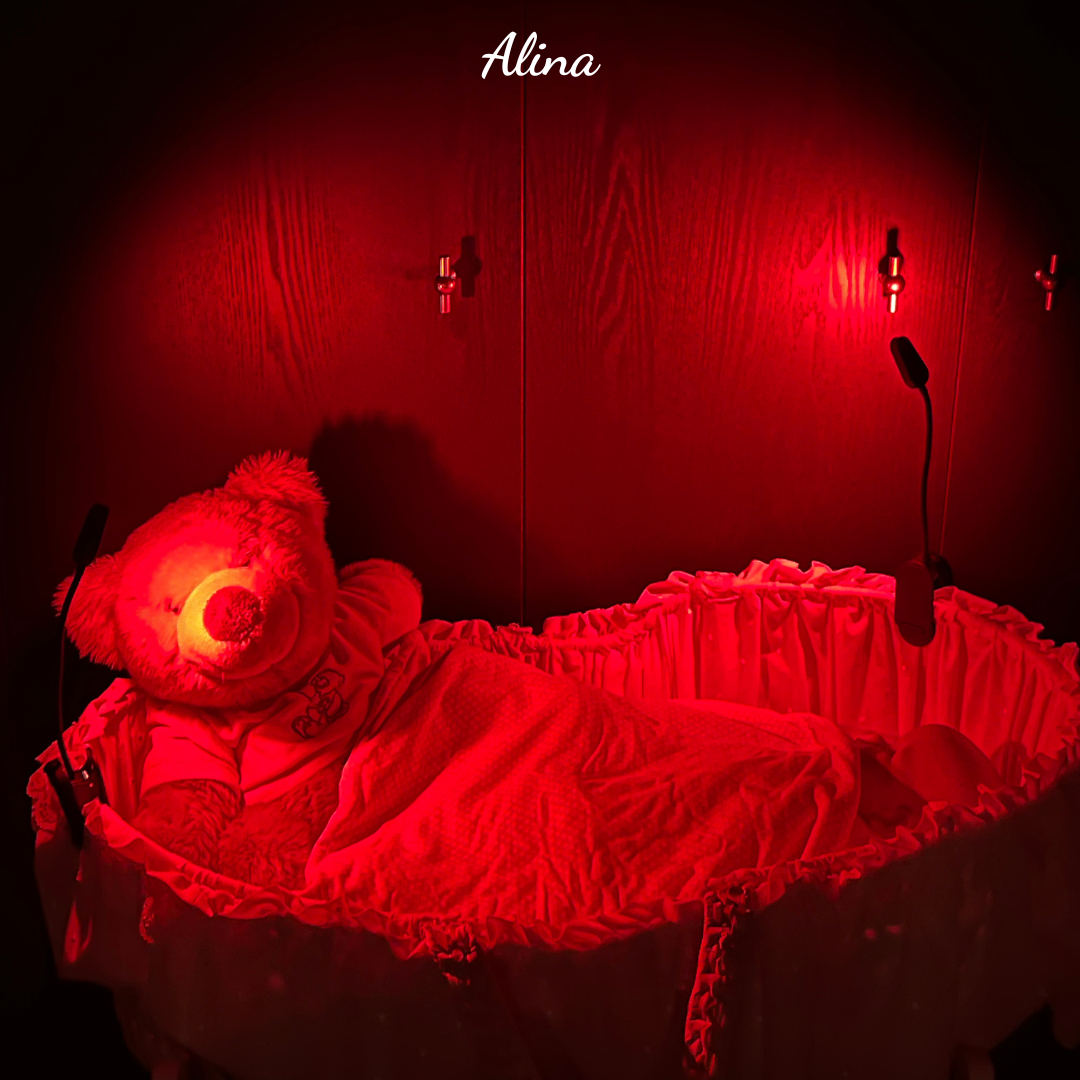 Baby in een wieg met de alina roodlichtlampen