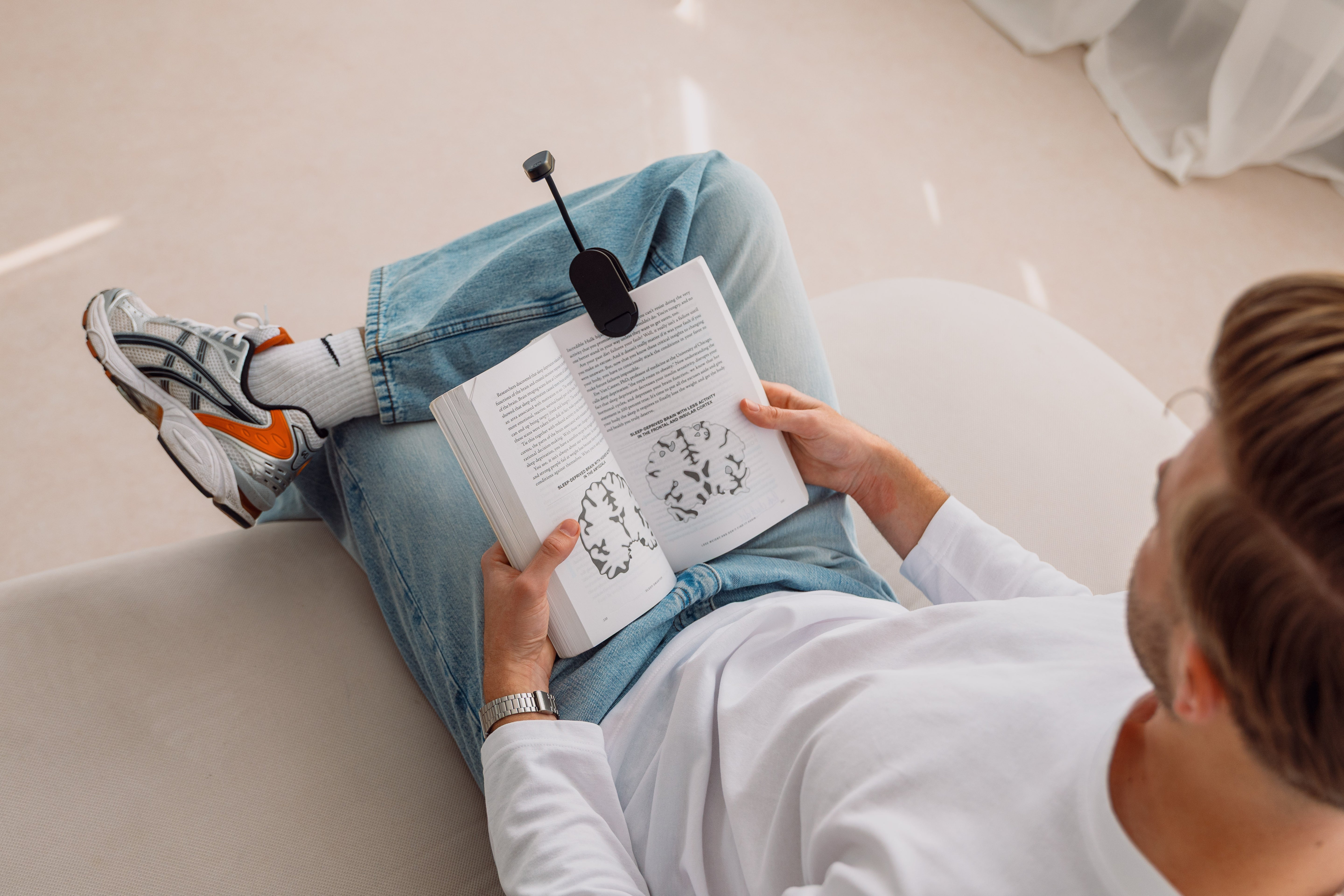 Sitzender Mann beim Lesen mit einer Rotlicht-Leselampe von Alina