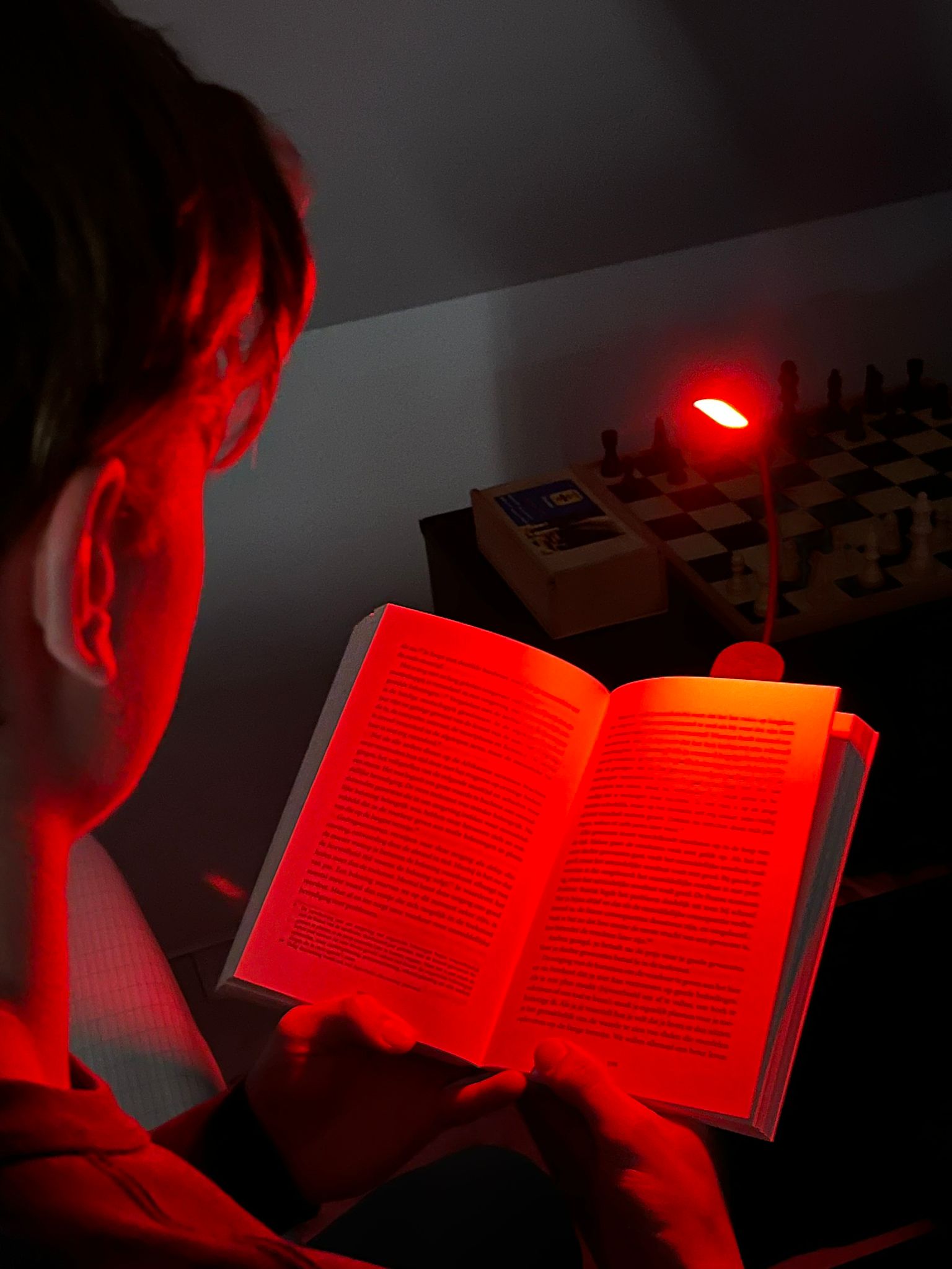 Man die zit te lezen met het Alina roodlicht leeslampje