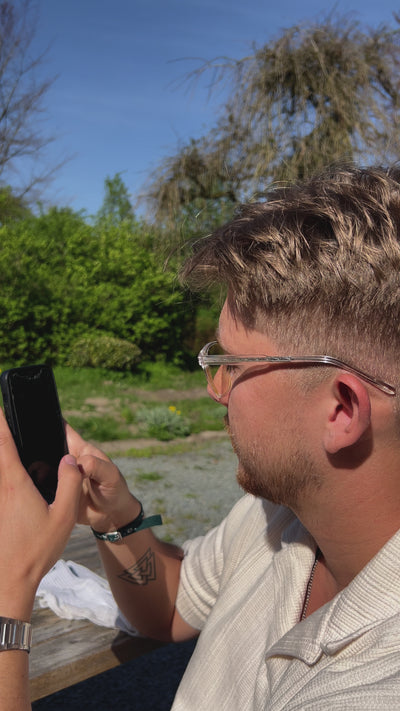 Iemand die op zijn telefoon zit met de blauwlicht bril op