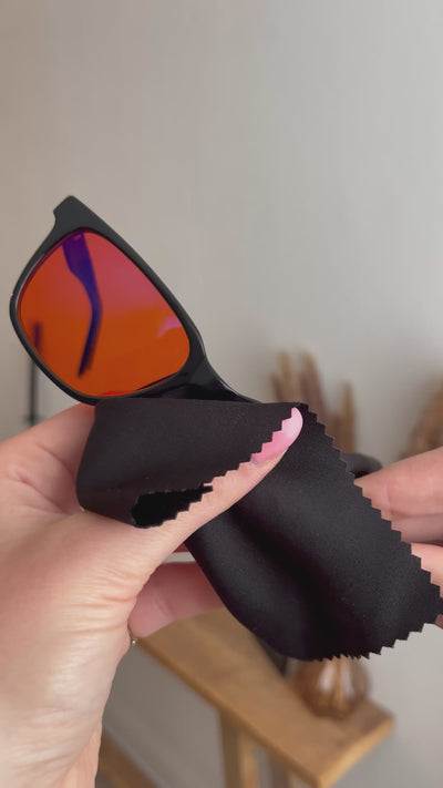 Blauwlicht bril die met het bijgeleverde doekje wordt schoongemaakt